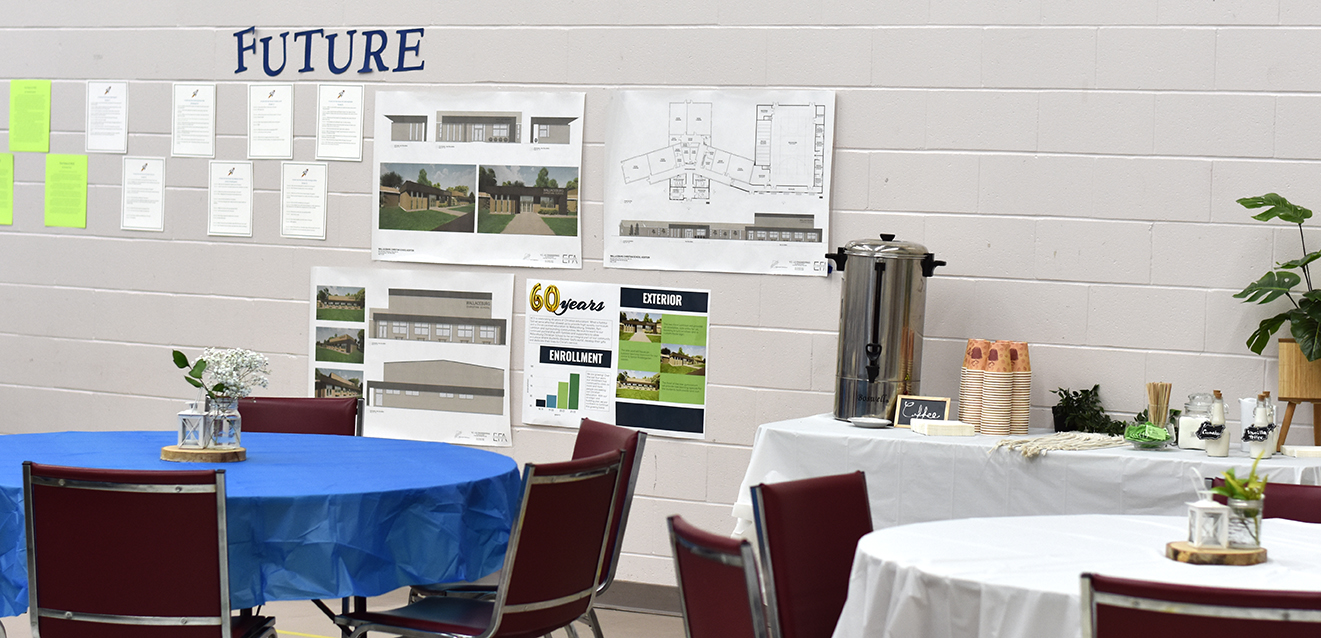 Tables and chairs set up in a gym with a coffee station