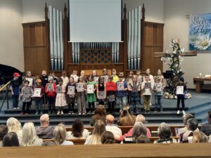 Kids reciting a poem at the front of the church