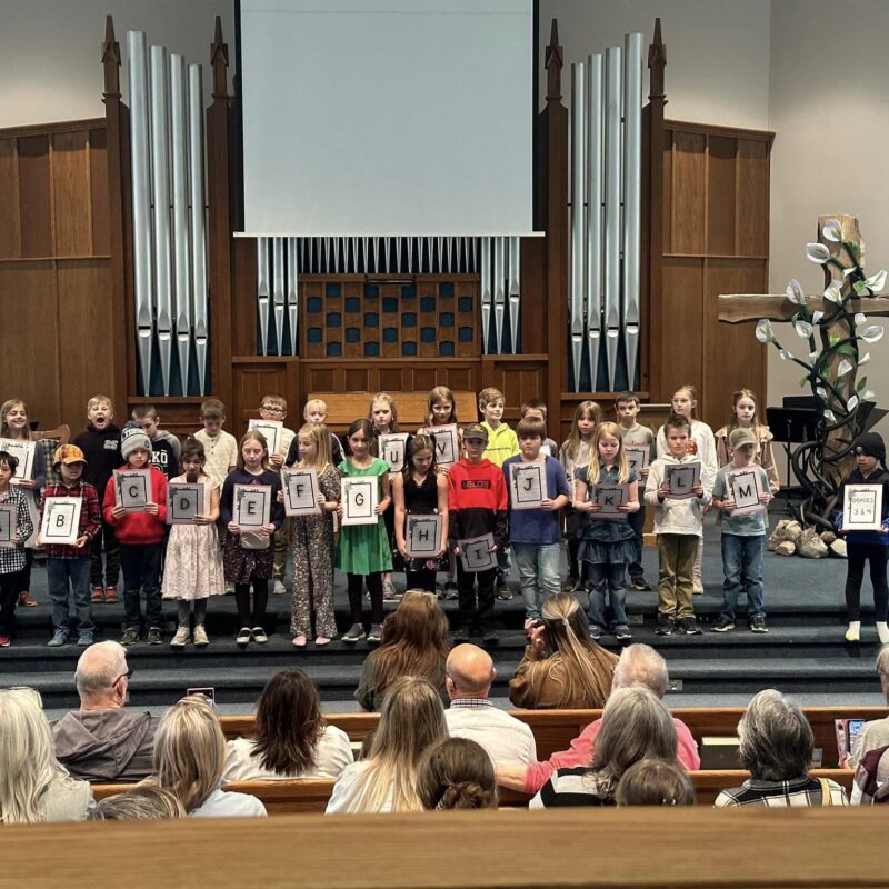Kids reciting a poem at the front of the church