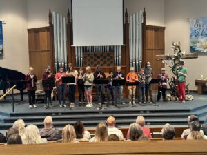 Kids playing instruments at the front of the church