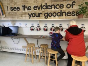 A grandparents sitting with a child at a table in a classroom
