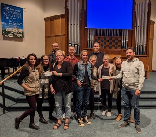 Group of adults accepting a donation cheque in a church