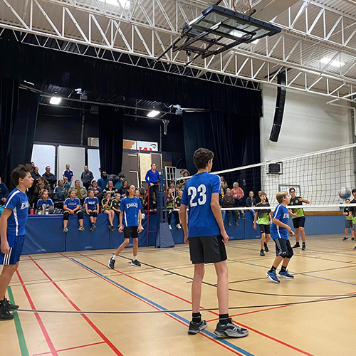 Boys playing volleyball in a gym