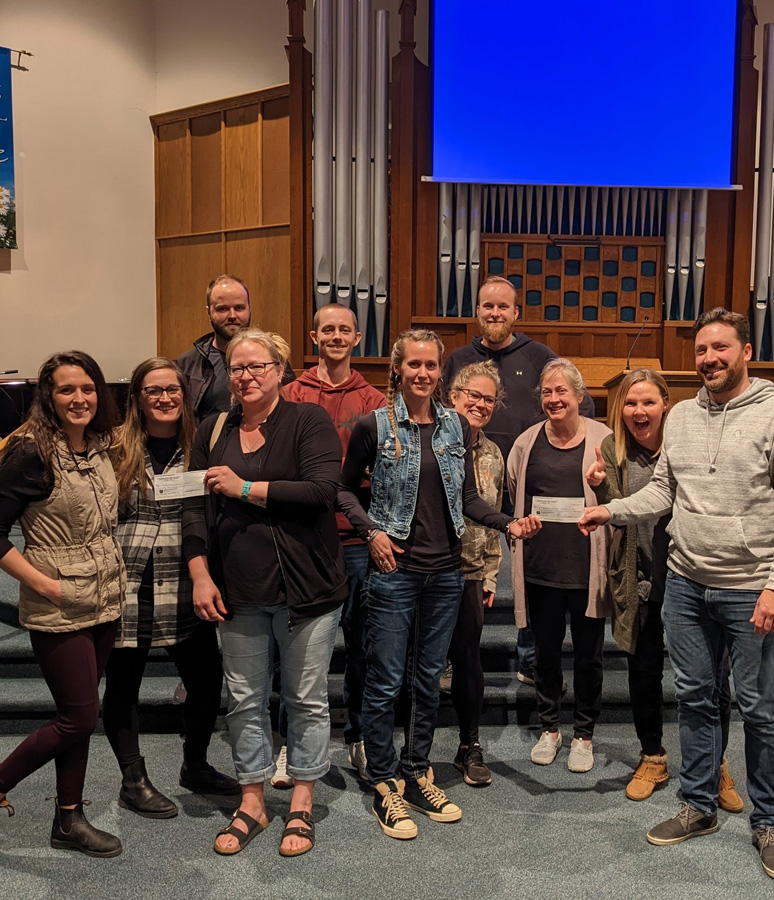 Group of people accepting a donation cheque in a church setting