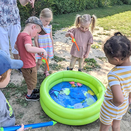 Preschoolers playing with fishing rods and water
