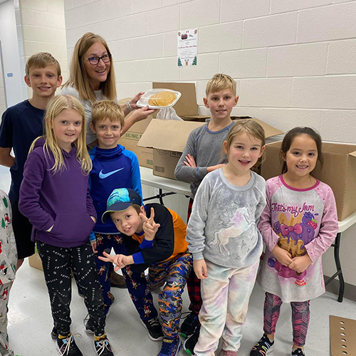 Group of kids with a teacher in a hallway