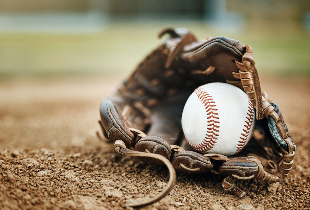 Baseball glove and ball outside in dirt