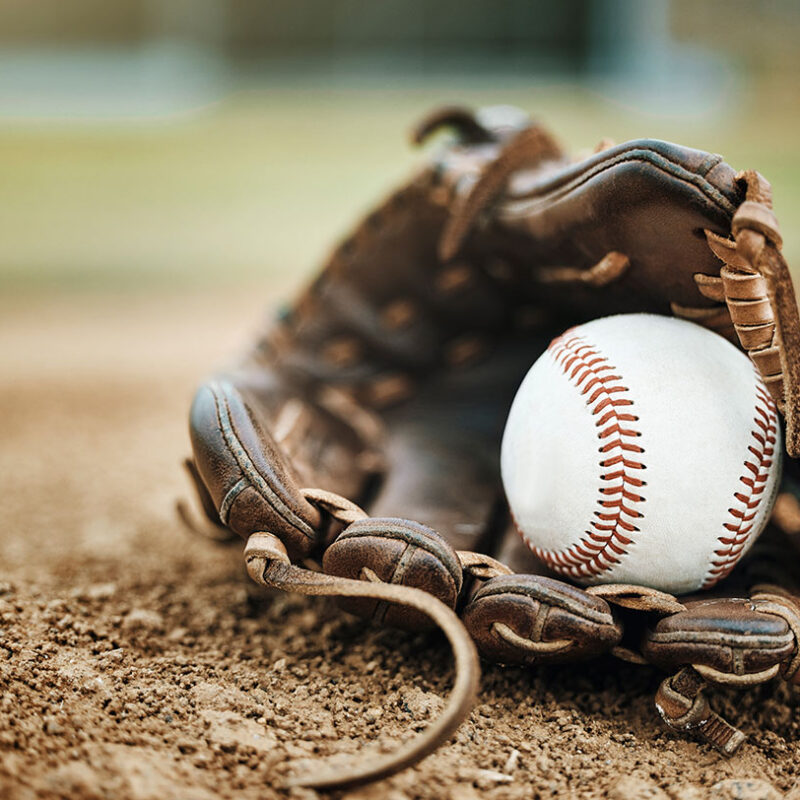 Baseball glove and ball outside in dirt